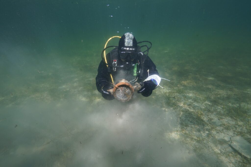 archaeologist diver holding a piece of amphora Sicily Italy