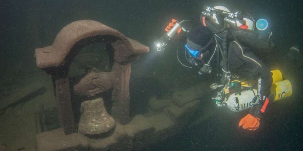Scuba divers bring sculpture from mysterious wreck to the surface